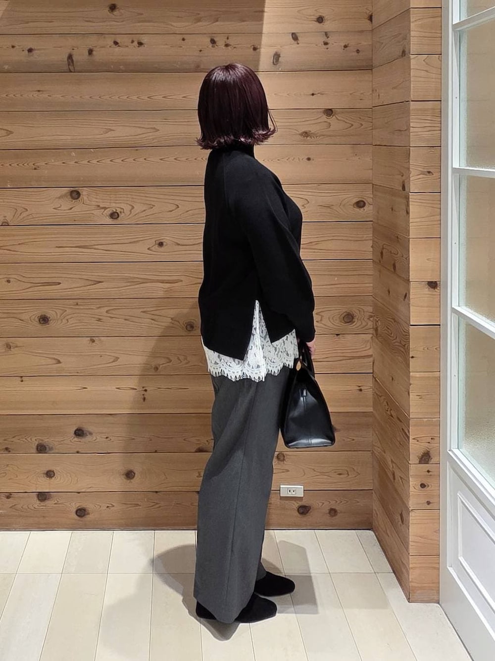 グレー系のチェスターコート、グレー系のその他パンツ、ブラック系のショルダーバッグを着用したレディースの冬コーディネートの2枚目の写真