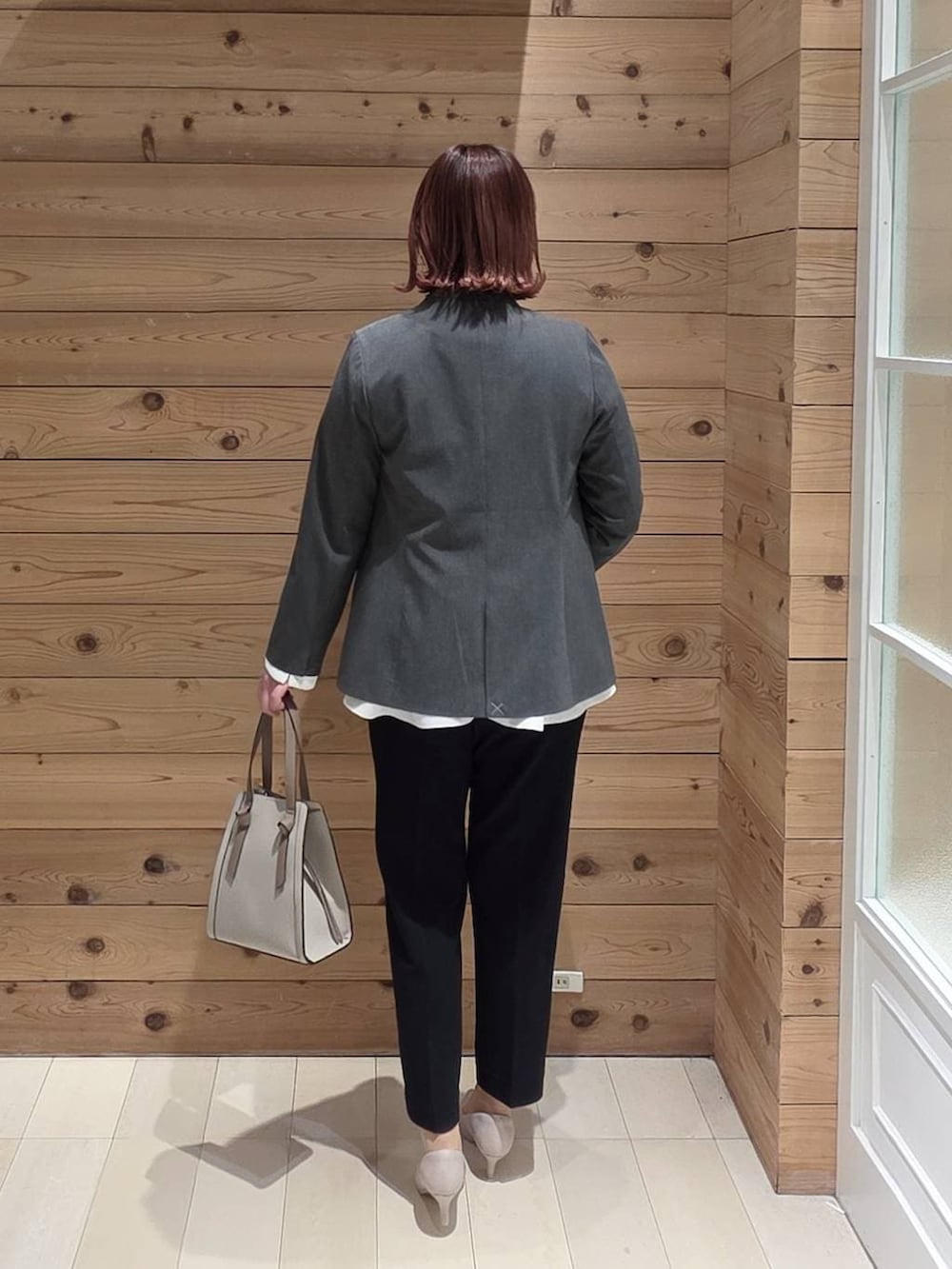 ホワイト系のショルダーバッグ、ホワイト系のパンプス、ブルー系のセットアップを着用したレディースの冬コーディネートの3枚目の写真