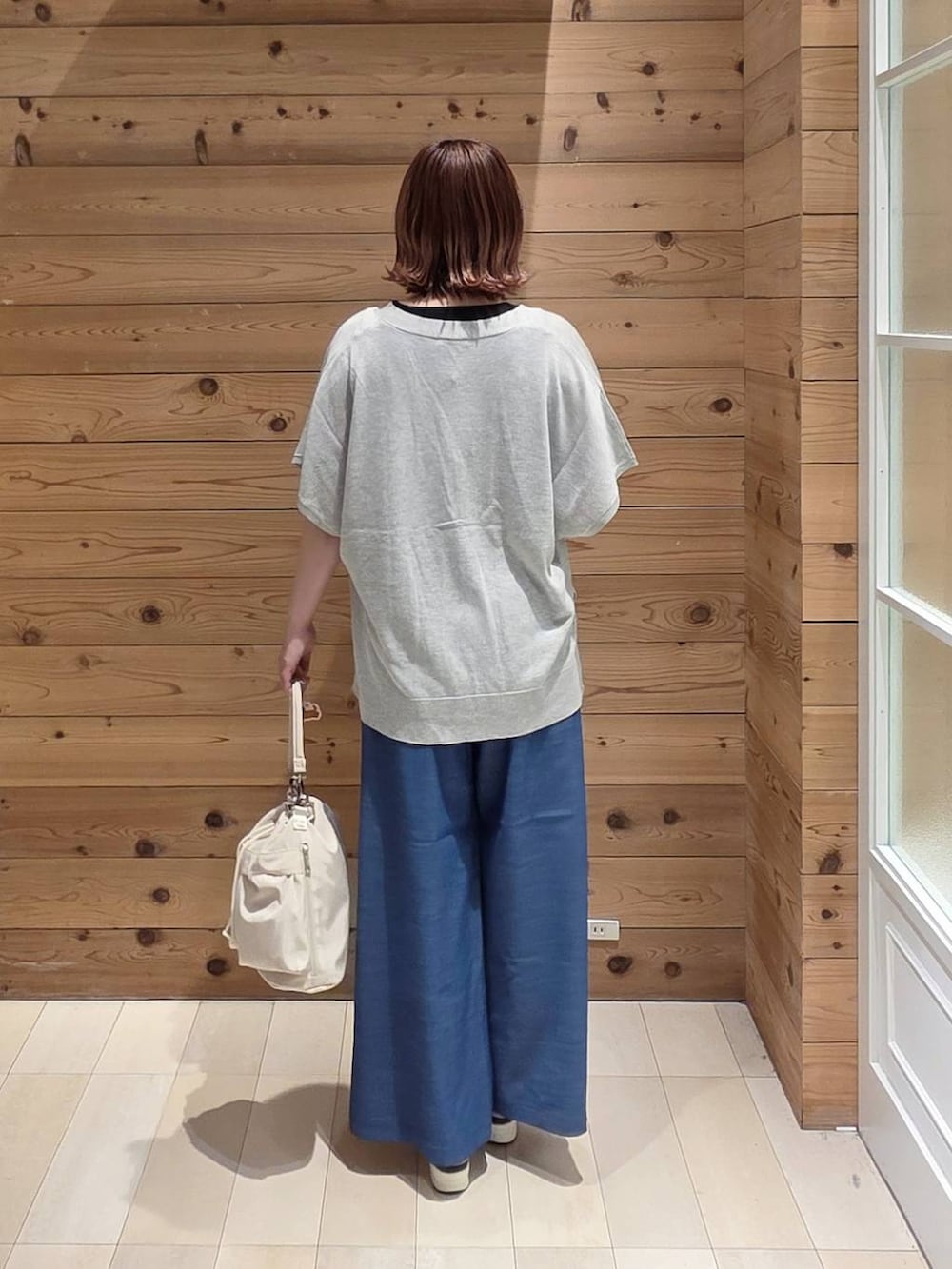 ホワイト系のショルダーバッグ、グレー系のカーディガン/ボレロ、ブルー系のその他パンツを着用したレディースの春コーディネートの3枚目の写真