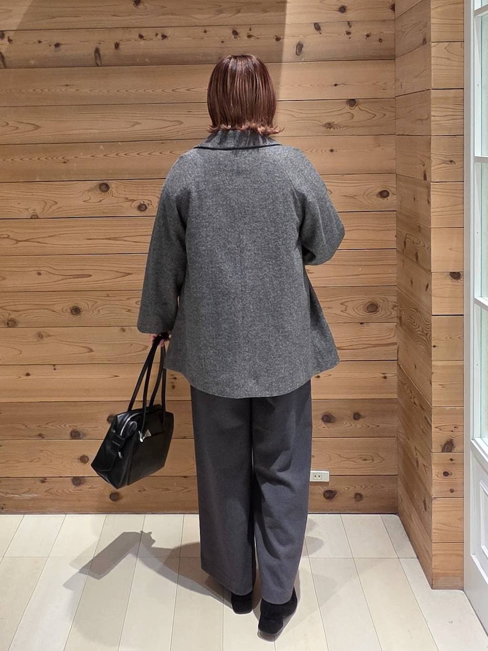 ブラック系のボストンバッグ、グレー系のチェスターコート、ホワイト系のシャツ/ブラウスを着用したレディースの冬コーディネートの3枚目の写真