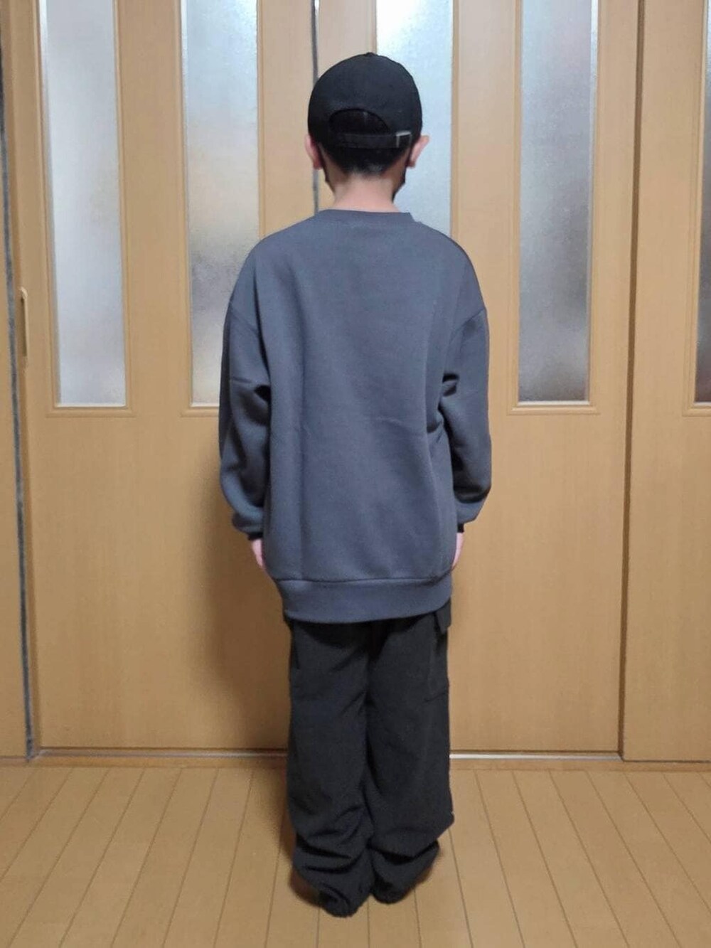 ベージュ系のブルゾン、ブラック系のカーゴパンツ、グレー系のスウェットを着用したキッズの冬コーディネートの3枚目の写真