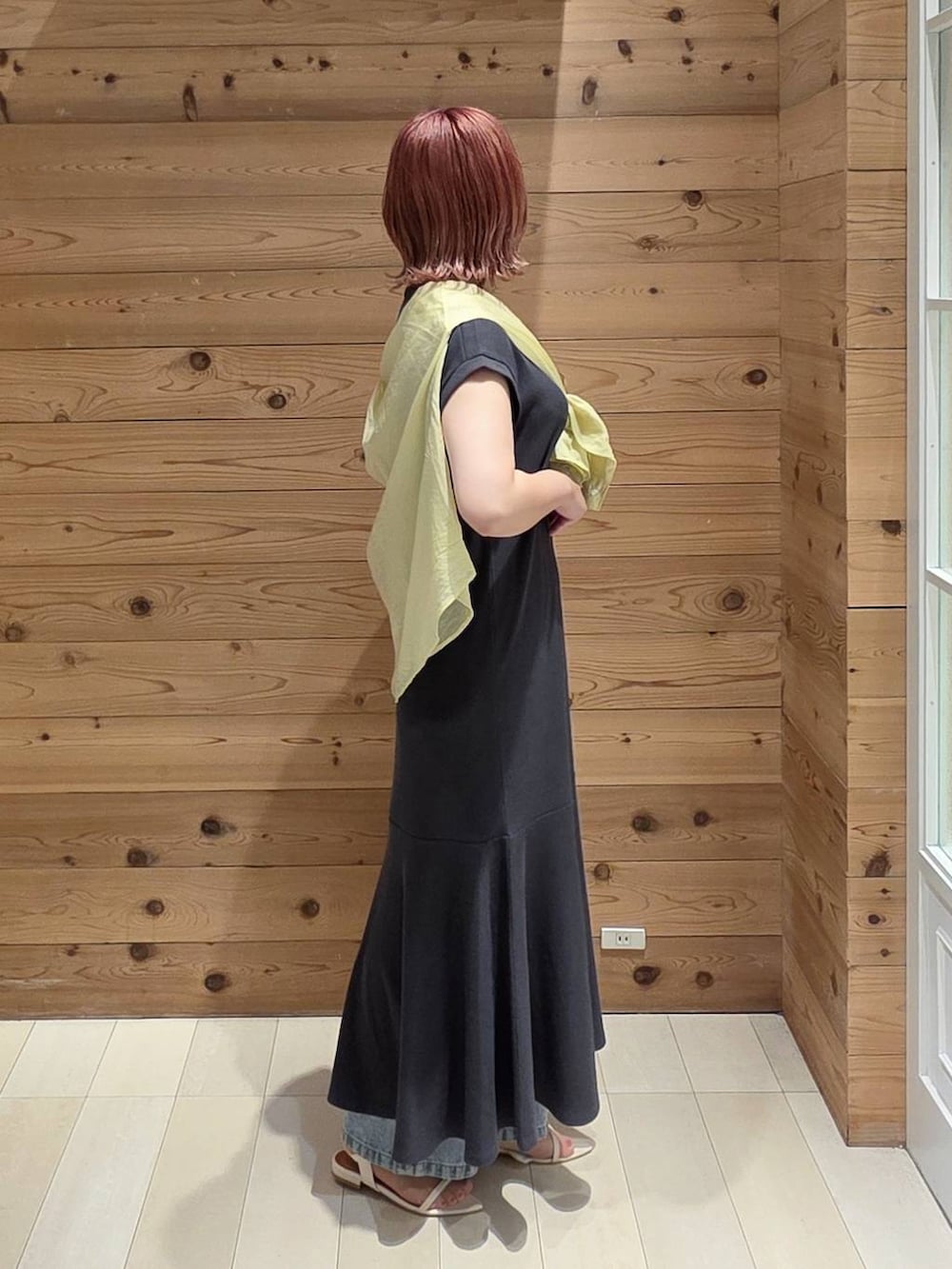 ブルー系のデニムパンツ、イエロー系のシャツ/ブラウス、シルバー系のショルダーバッグを着用したレディースの夏コーディネートの2枚目の写真