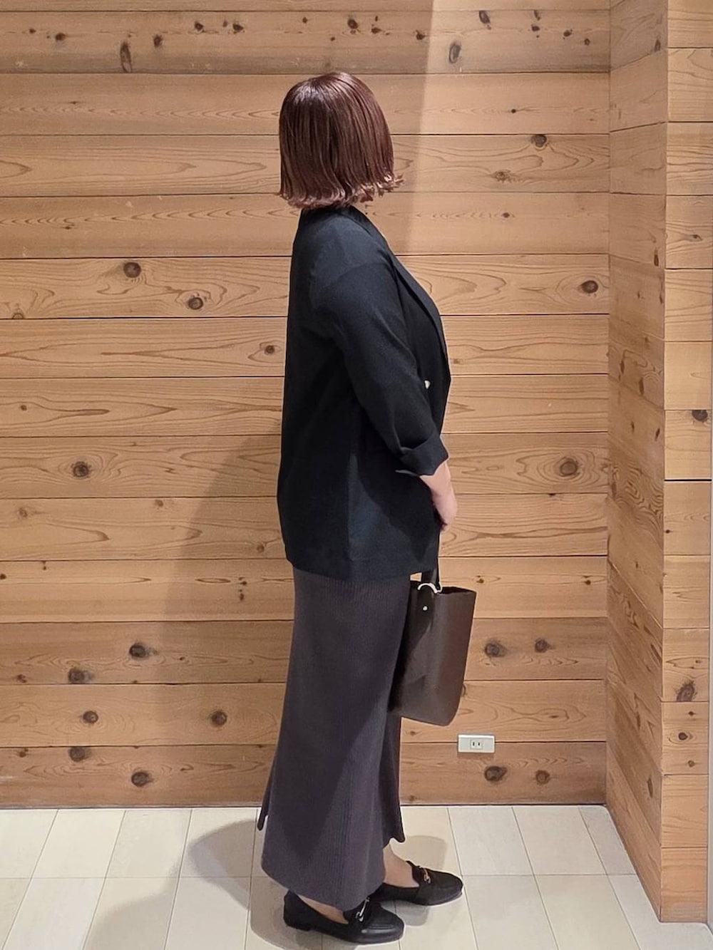 ブラック系のローファー、ブラウン系のショルダーバッグ、ブルー系のテーラードジャケットを着用したレディースの秋コーディネートの2枚目の写真