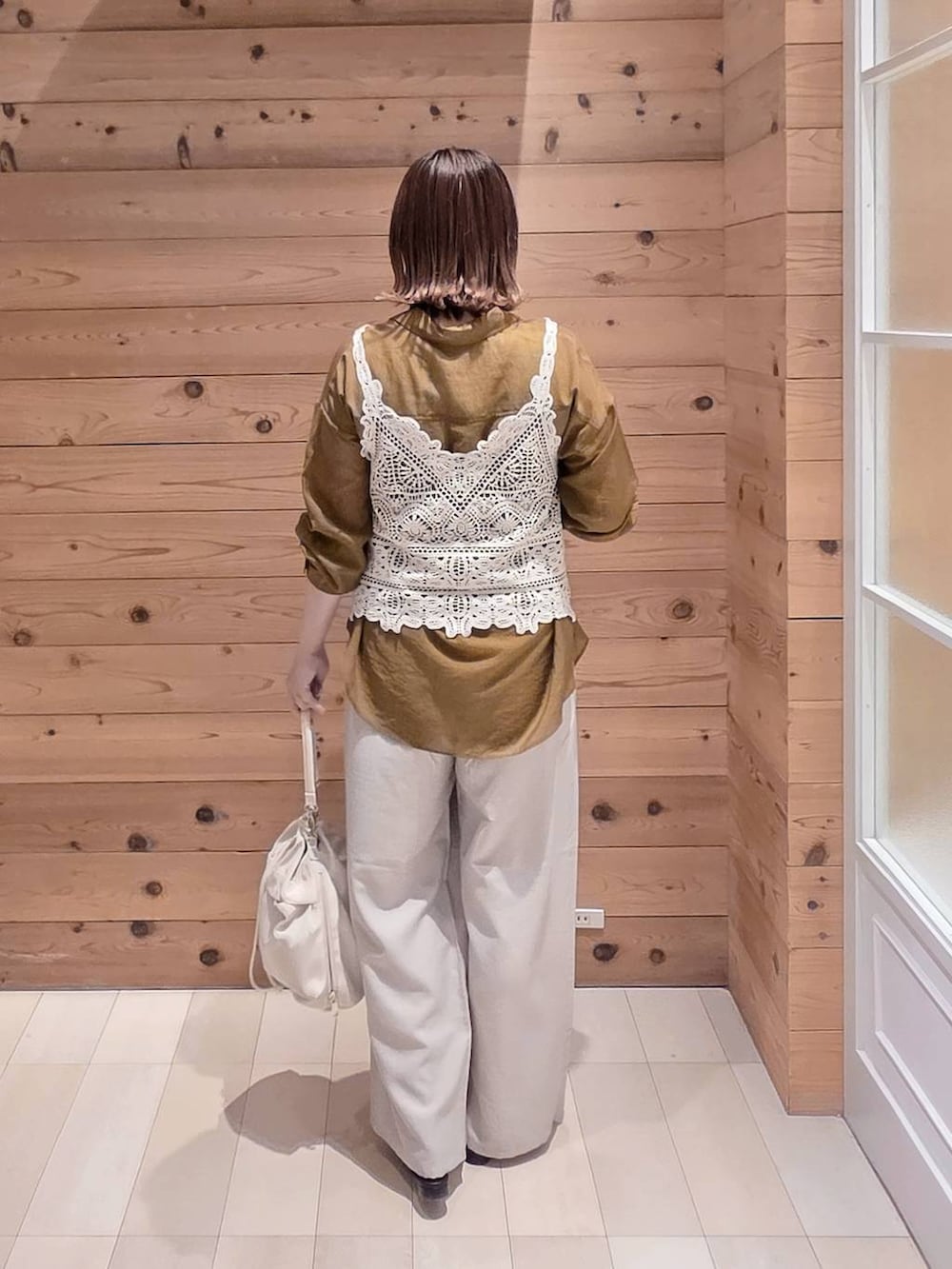 ホワイト系のショルダーバッグ、ベージュ系のその他パンツ、ホワイト系のタンクトップを着用したレディースの夏コーディネートの3枚目の写真
