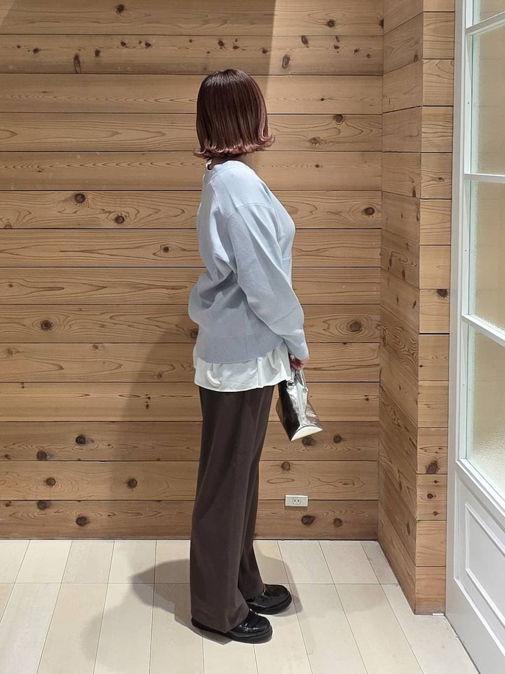 シルバー系のショルダーバッグ、ブラック系のローファー、ブラック系のマウンテンパーカーを着用したレディースの春コーディネートの2枚目の写真