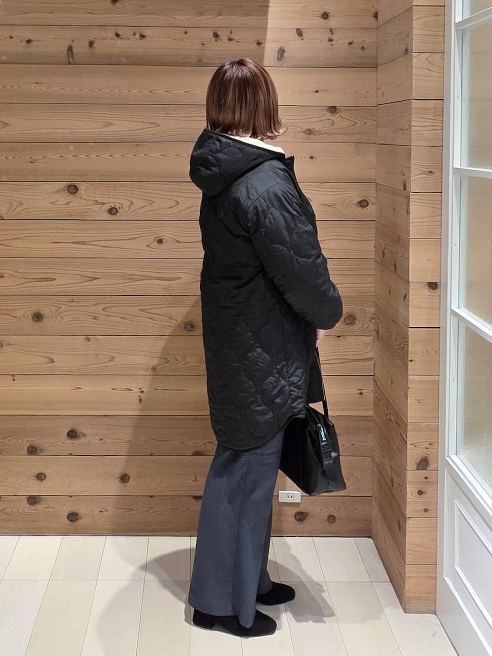 ブラック系のボストンバッグ、ブラック系のブルゾン、ブルー系のその他パンツを着用したレディースの冬コーディネートの2枚目の写真