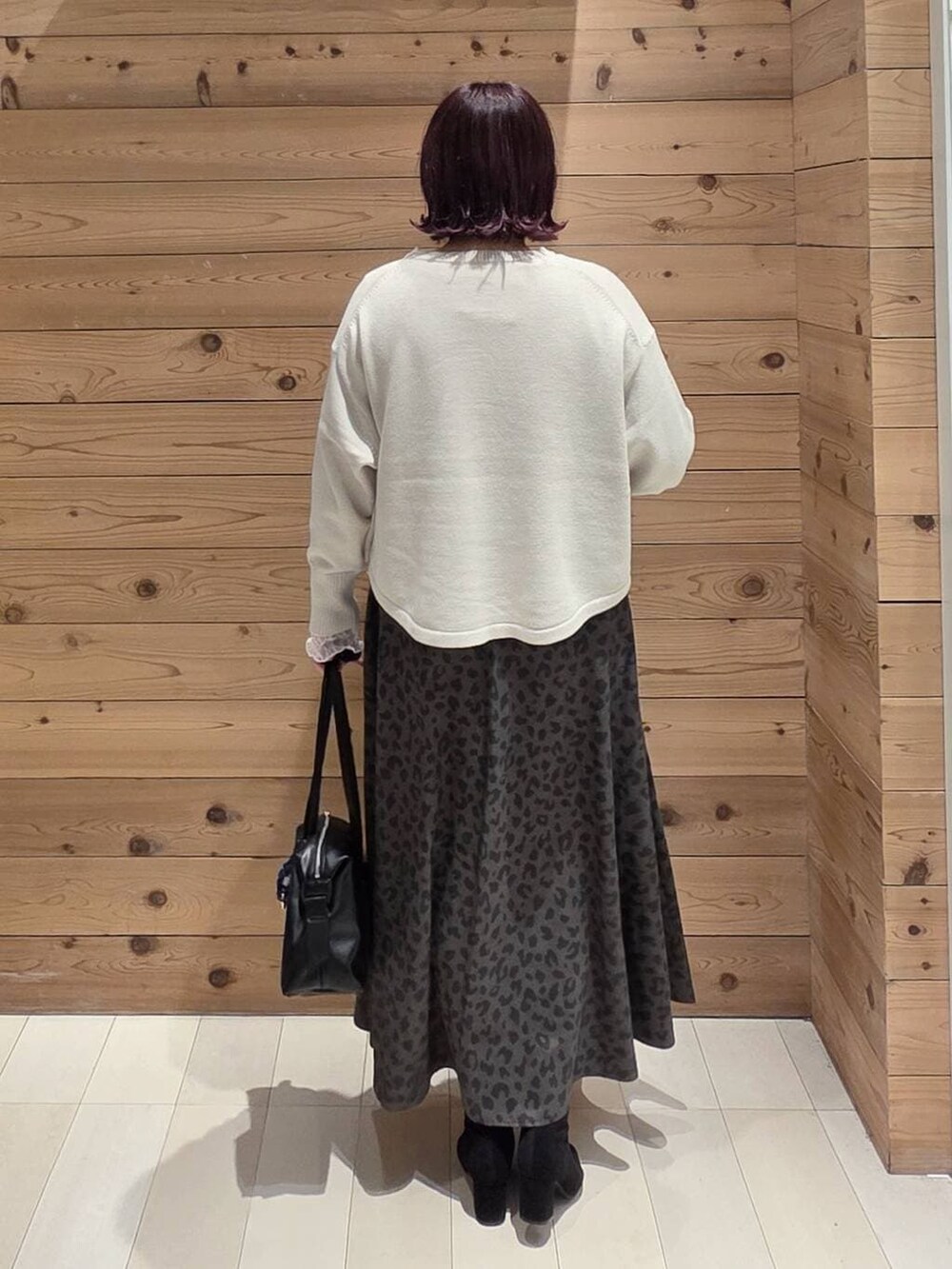 ホワイト系のマウンテンパーカー、ベージュ系のニット/セーター、ブラック系のボストンバッグを着用したレディースの冬コーディネートの3枚目の写真