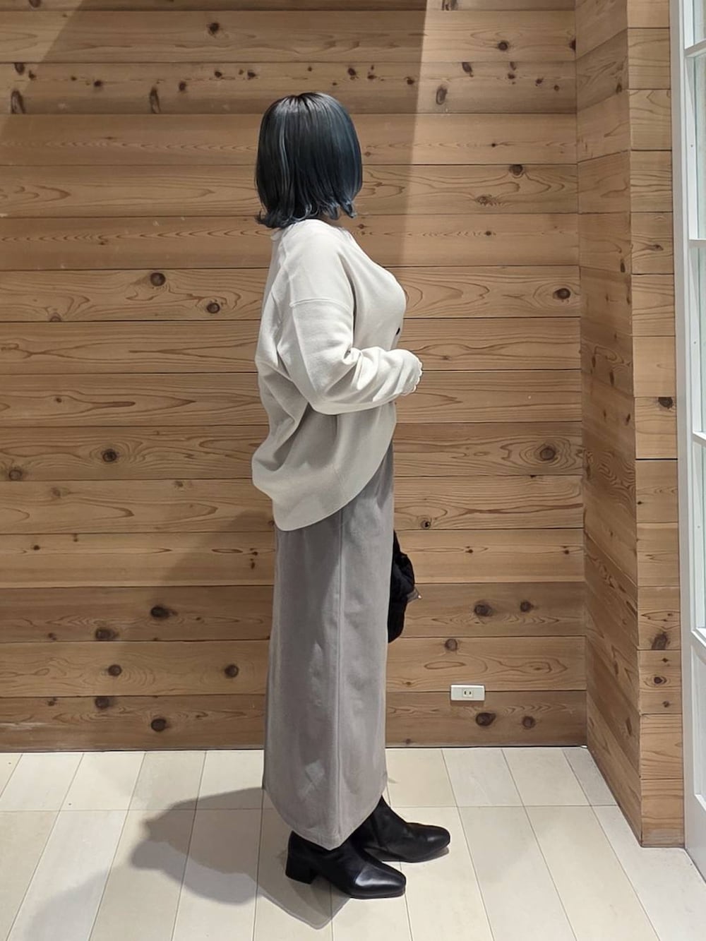 ホワイト系のTシャツ/カットソー、ブラック系のトートバッグ、グリーン系のカーディガン/ボレロを着用したレディースの秋コーディネートの2枚目の写真