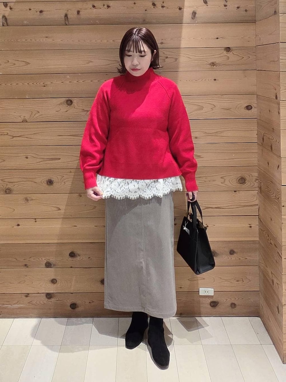 ブラック系のショルダーバッグ、ブラウン系のチェスターコート、ブラウン系のスカートを着用したレディースの冬コーディネートの4枚目の写真