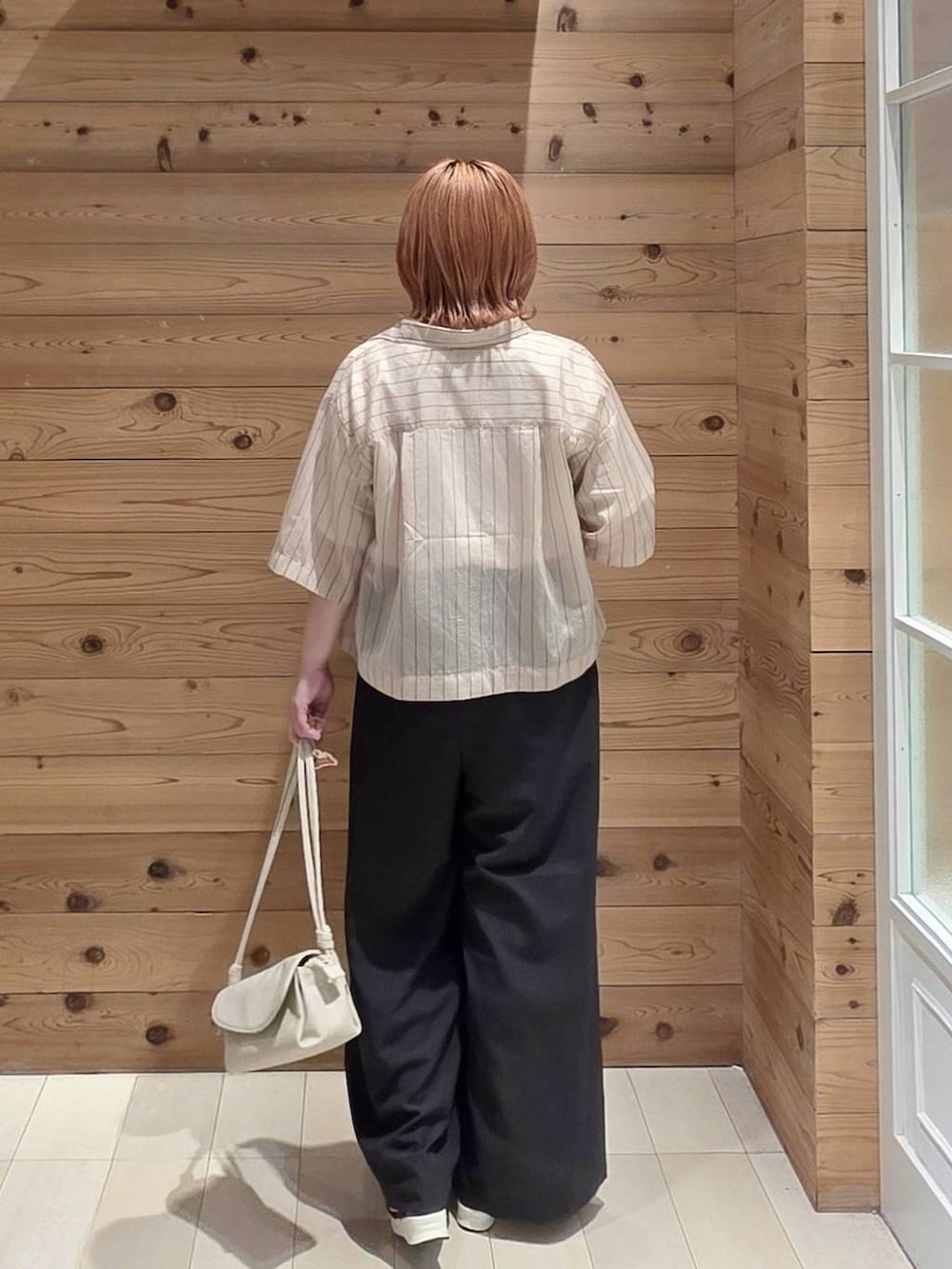 ベージュ系のショルダーバッグ、ブラック系のその他パンツ、ベージュ系のシャツ/ブラウスを着用したレディースの夏コーディネートの3枚目の写真