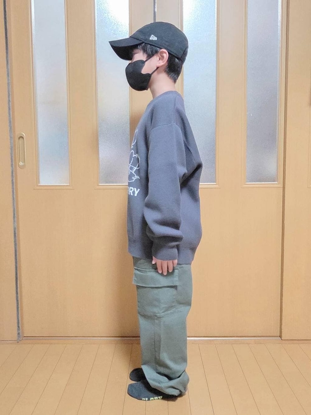 グリーン系のカーゴパンツ、グレー系のニット/セーターを着用したキッズの冬コーディネートの2枚目の写真