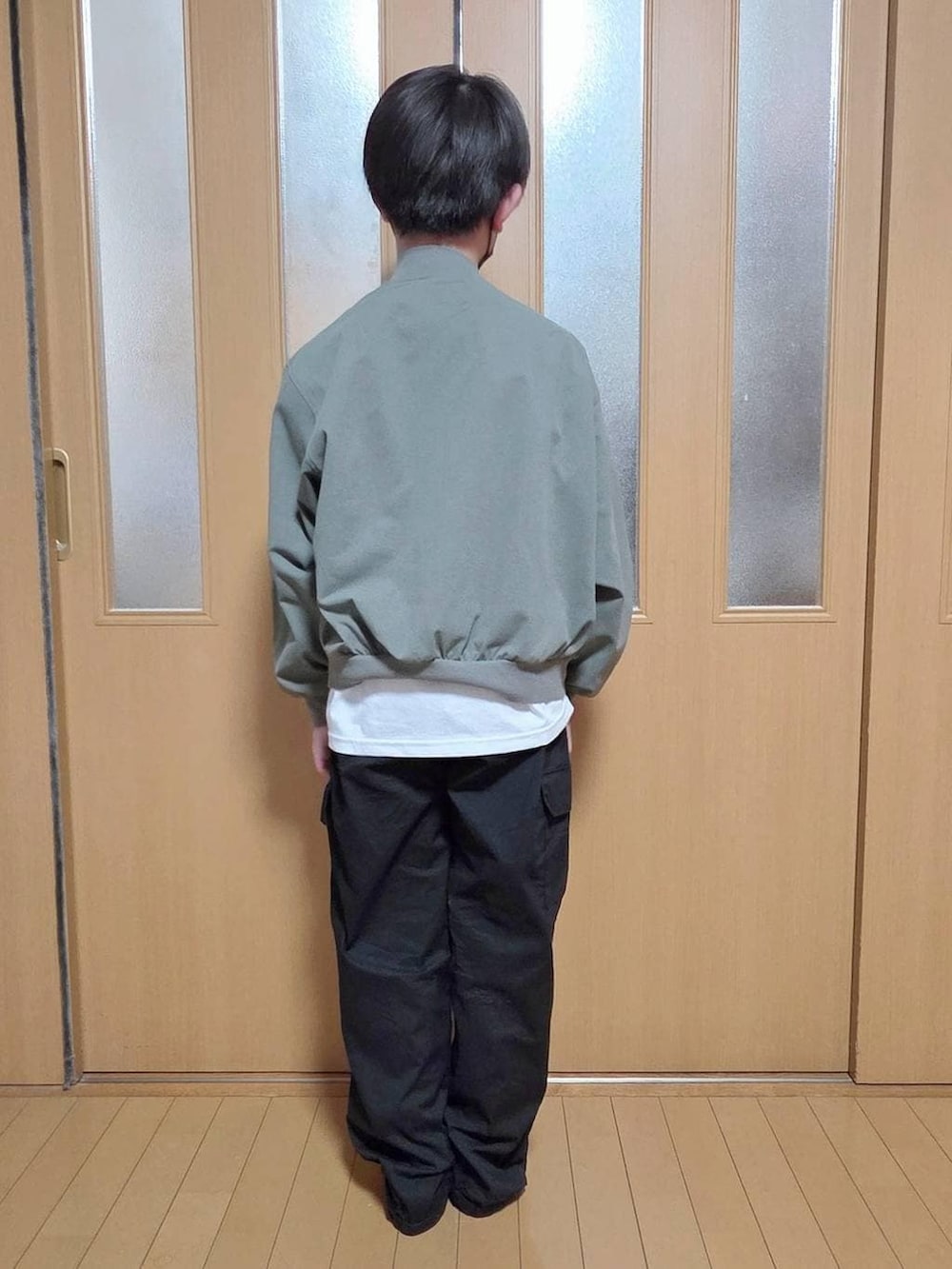 ブラック系のカーゴパンツ、グリーン系のMA-1、ホワイト系のTシャツ/カットソーを着用したキッズの春コーディネートの3枚目の写真