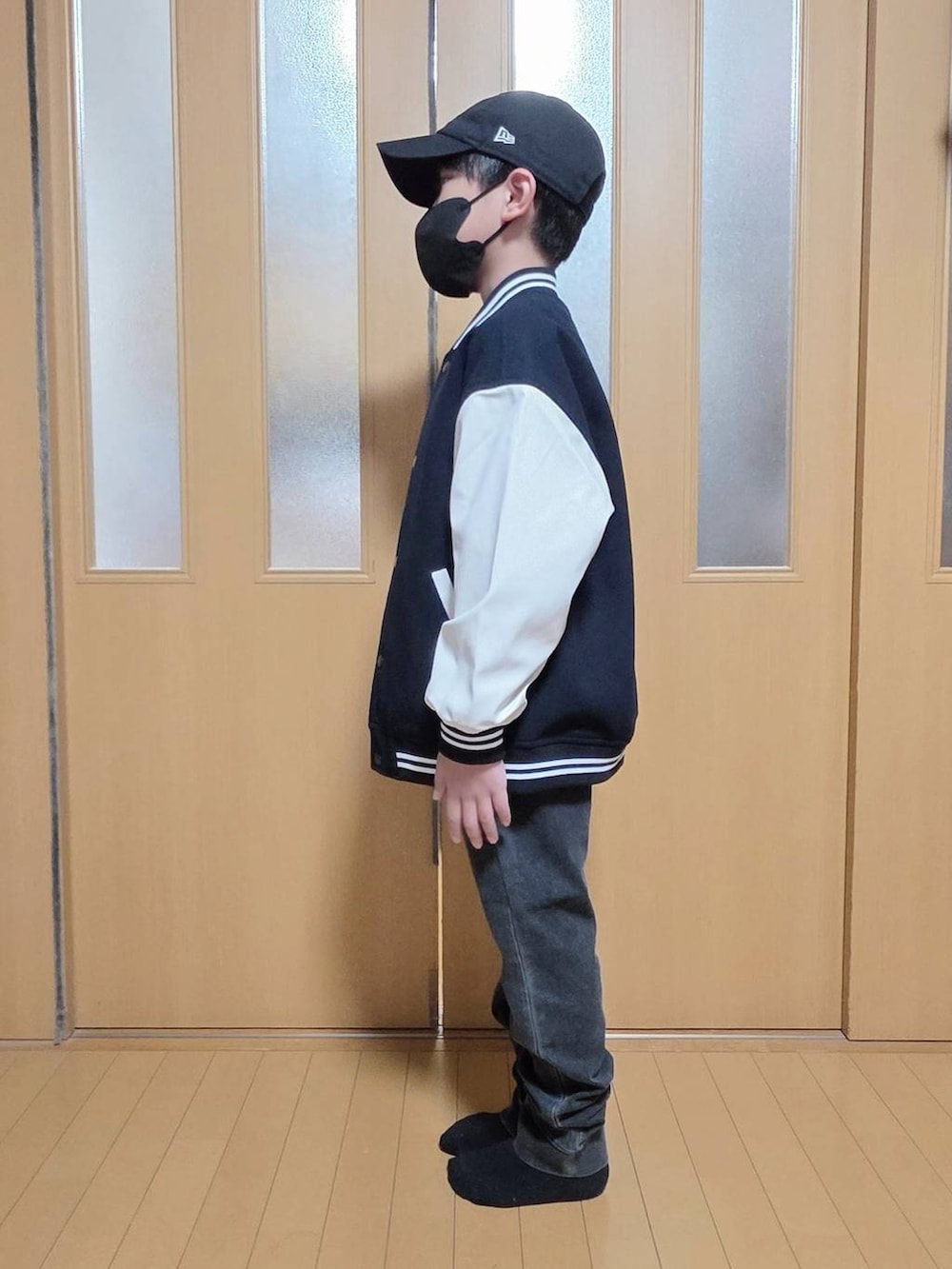 ブルー系のブルゾン、ブラック系のデニムパンツ、グレー系のスウェットを着用したキッズの秋コーディネートの2枚目の写真