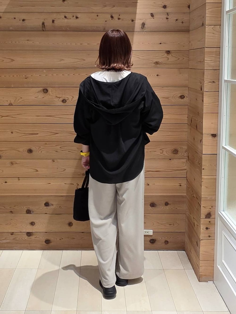 ホワイト系のTシャツ/カットソー、ブラック系のシャツ/ブラウス、ベージュ系のその他パンツを着用したレディースの春コーディネートの3枚目の写真