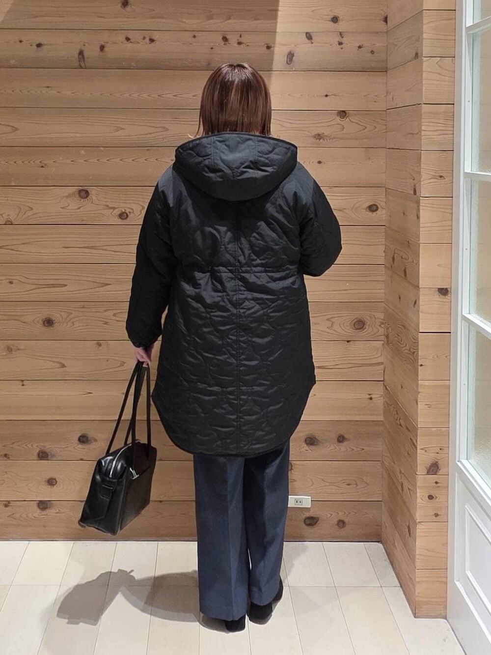 ブラック系のボストンバッグ、ブラック系のブルゾン、ブルー系のその他パンツを着用したレディースの冬コーディネートの3枚目の写真