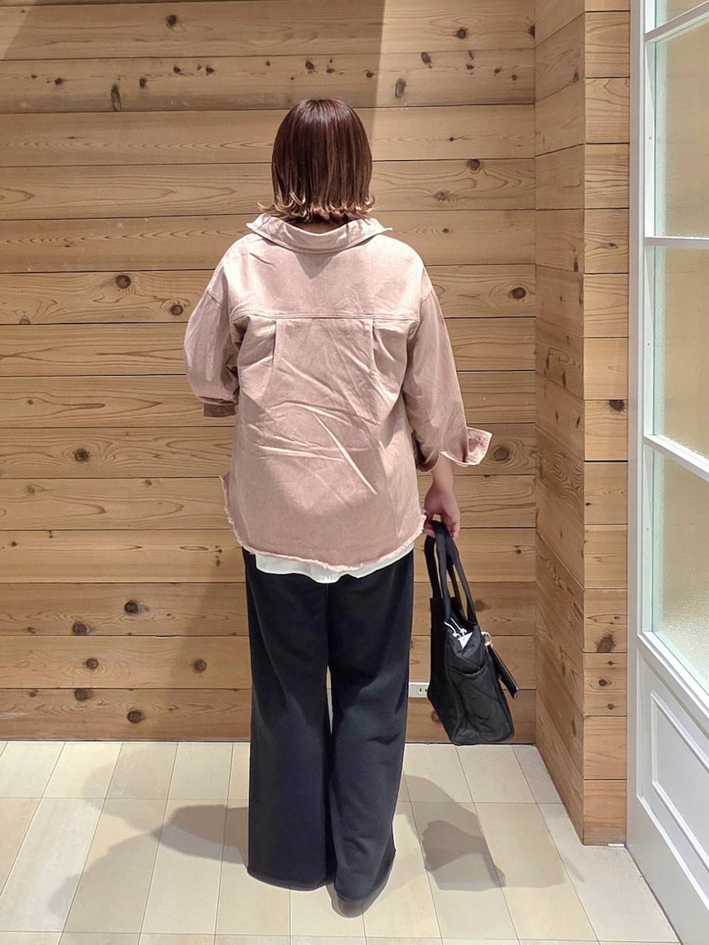 ブラック系のバレエシューズ、ブラック系のトートバッグ、ピンク系のシャツ/ブラウスを着用したレディースの春コーディネートの3枚目の写真