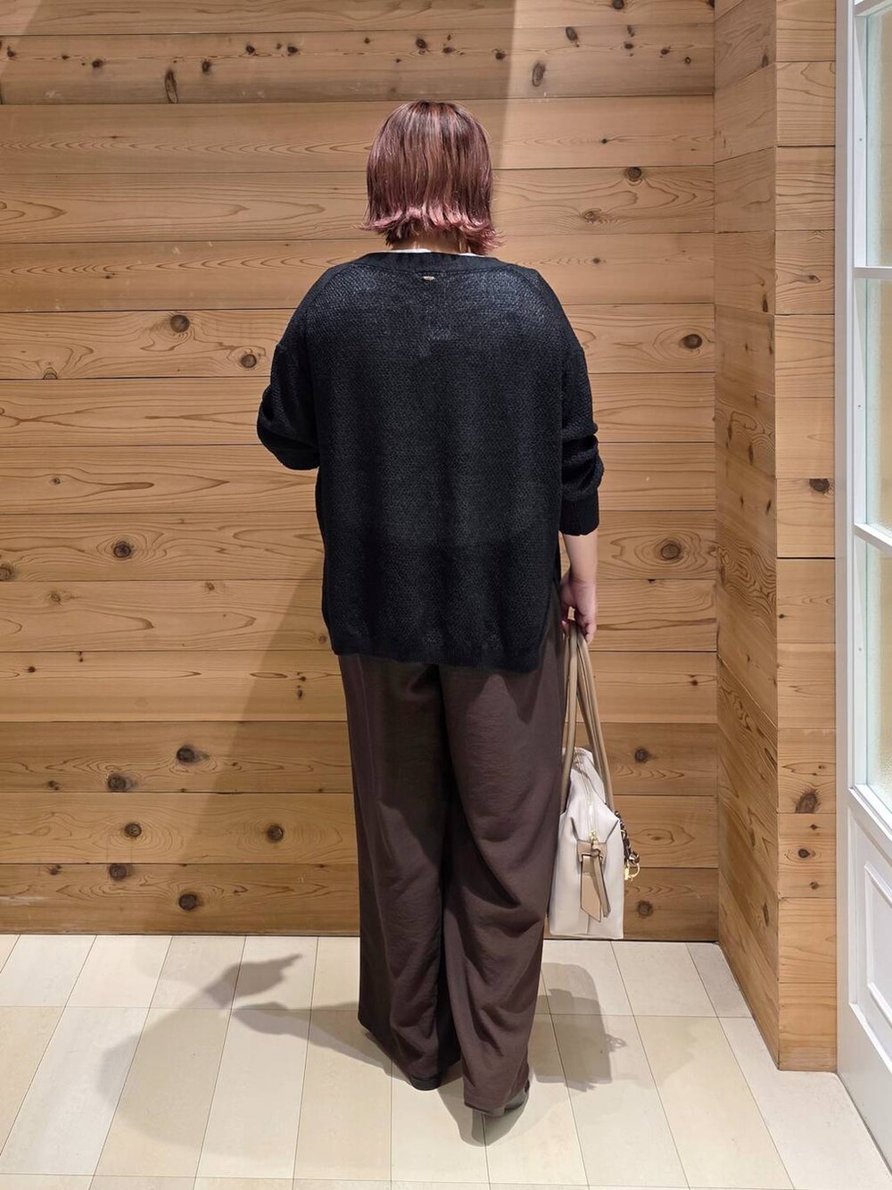 ブラック系のローファー、ブラウン系のその他パンツ、ホワイト系のボストンバッグを着用したレディースの秋コーディネートの3枚目の写真