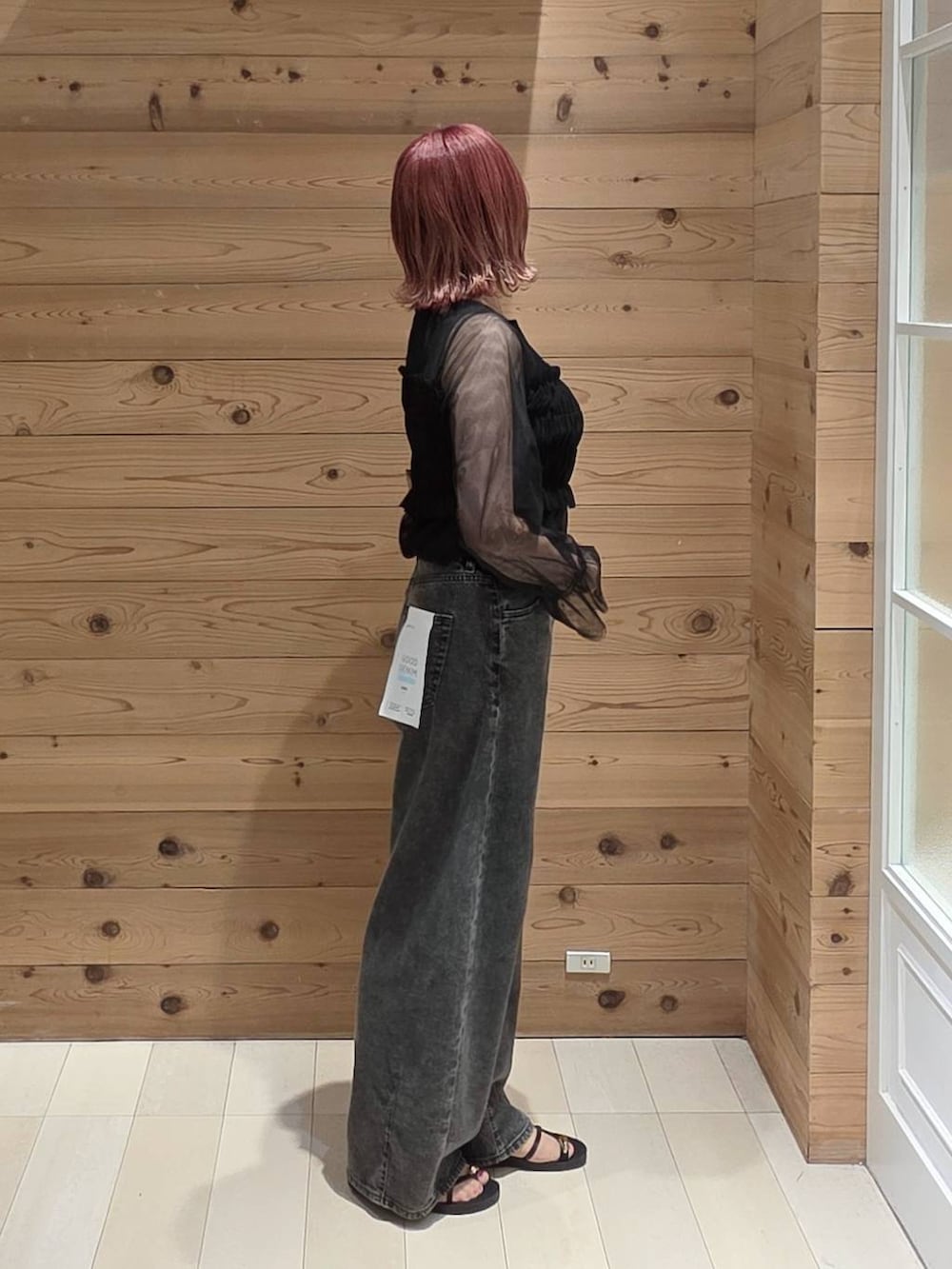 ブラック系のデニムパンツ、ブラック系のタンクトップ、ベージュ系のボディバッグ/ウエストポーチを着用したレディースの夏コーディネートの2枚目の写真