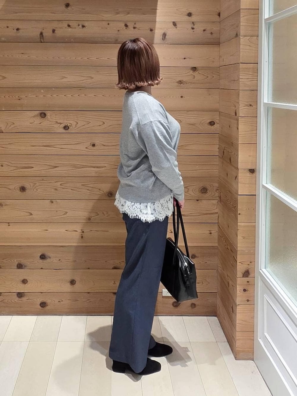 ブラック系のボストンバッグ、ブラック系のブルゾン、ブルー系のその他パンツを着用したレディースの冬コーディネートの2枚目の写真