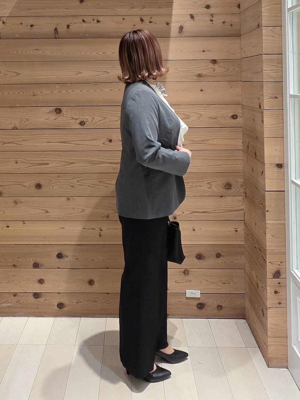 ブラック系のパンプス、ホワイト系のシャツ/ブラウス、グレー系のノーカラージャケットを着用したレディースの冬コーディネートの2枚目の写真