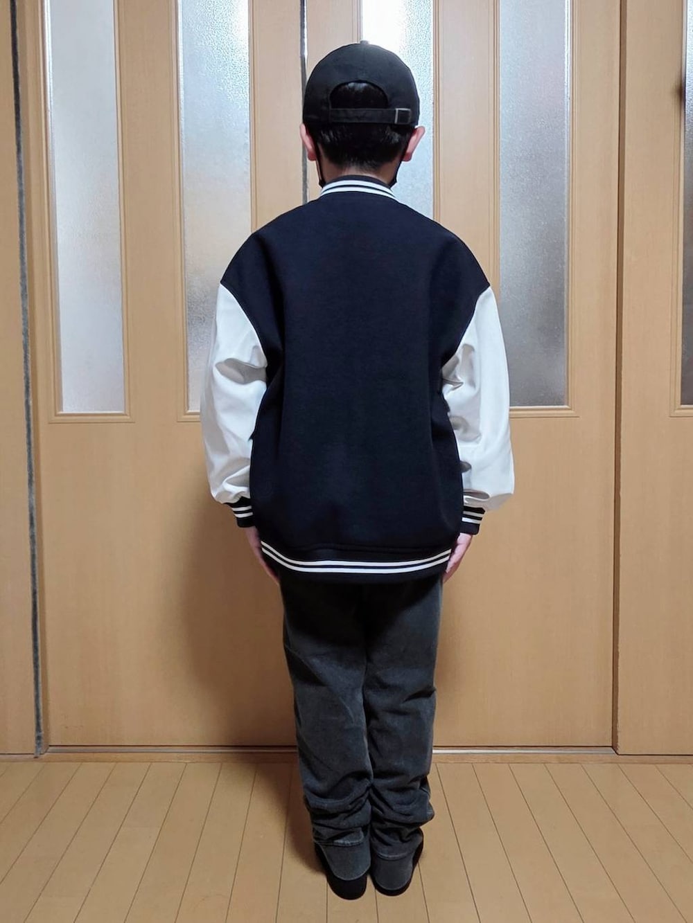 ブルー系のブルゾン、ブラック系のデニムパンツ、グレー系のスウェットを着用したキッズの秋コーディネートの3枚目の写真