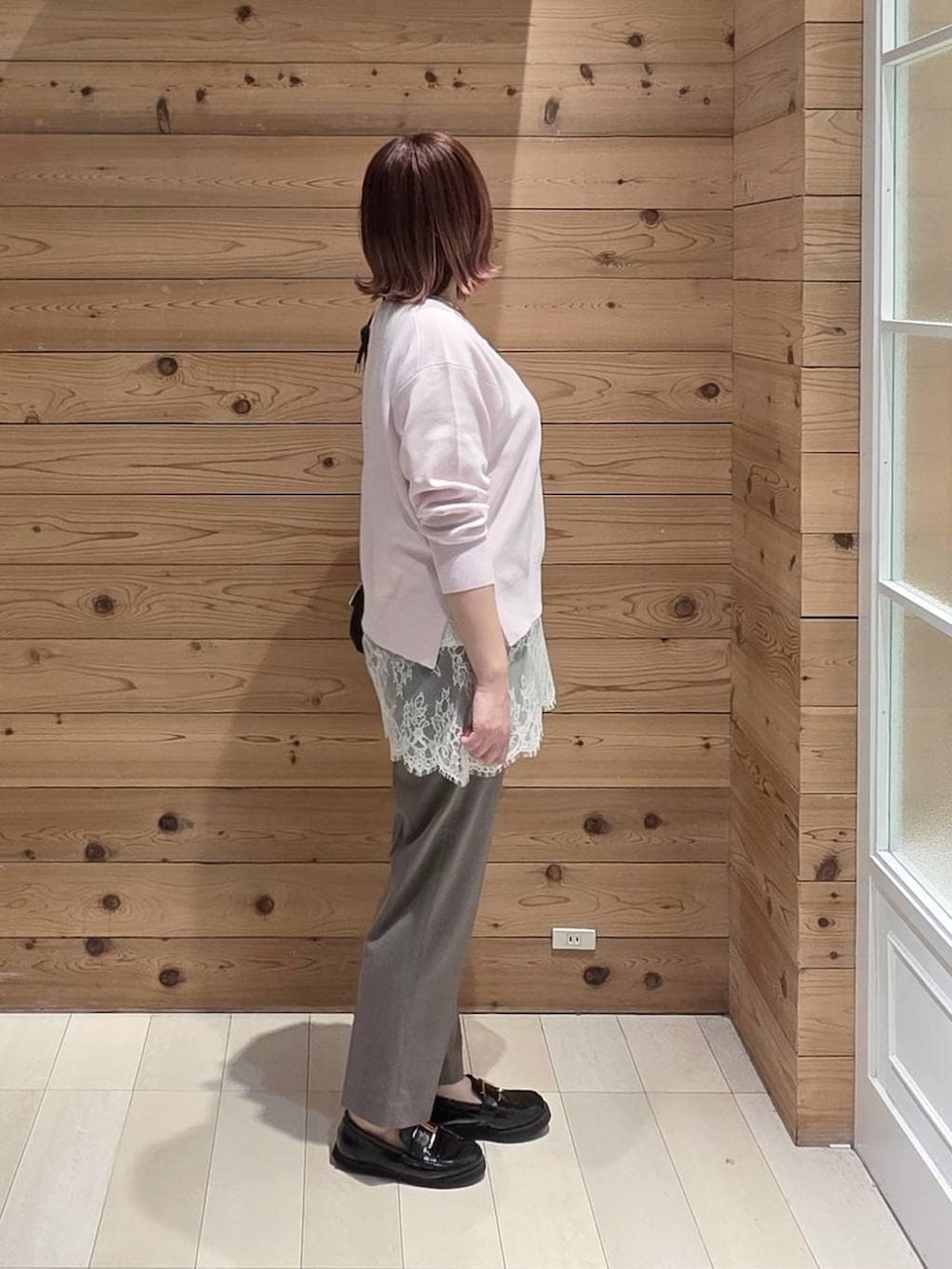 ブラック系のローファー、ブラック系のショルダーバッグ、ブラウン系のスラックスを着用したレディースの春コーディネートの2枚目の写真