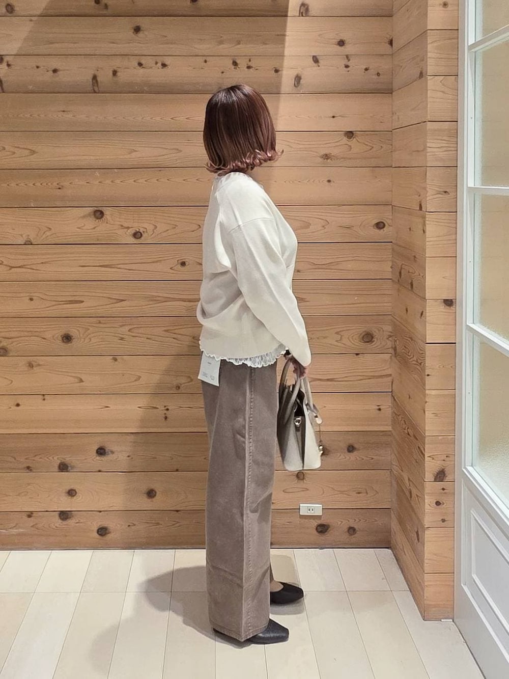 ブラック系のパンプス、ホワイト系のショルダーバッグ、ブラック系のマウンテンパーカーを着用したレディースの春コーディネートの2枚目の写真