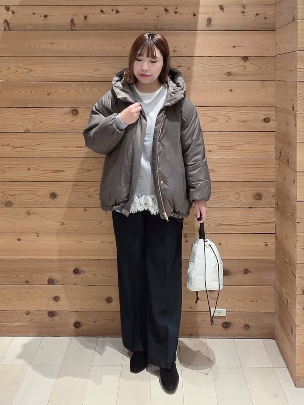 ブラウン系のダウンジャケット/コート、ホワイト系のハンドバッグ、ブルー系のその他パンツを着用したレディースの冬コーディネートの4枚目の写真