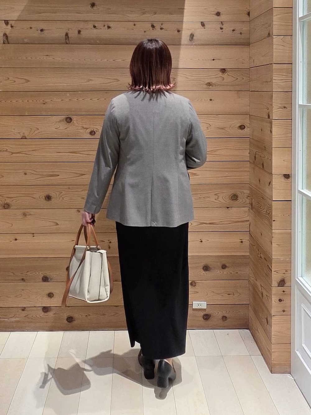 ブラック系のローファー、ホワイト系のトートバッグ、ブラウン系のノーカラージャケットを着用したレディースの冬コーディネートの3枚目の写真