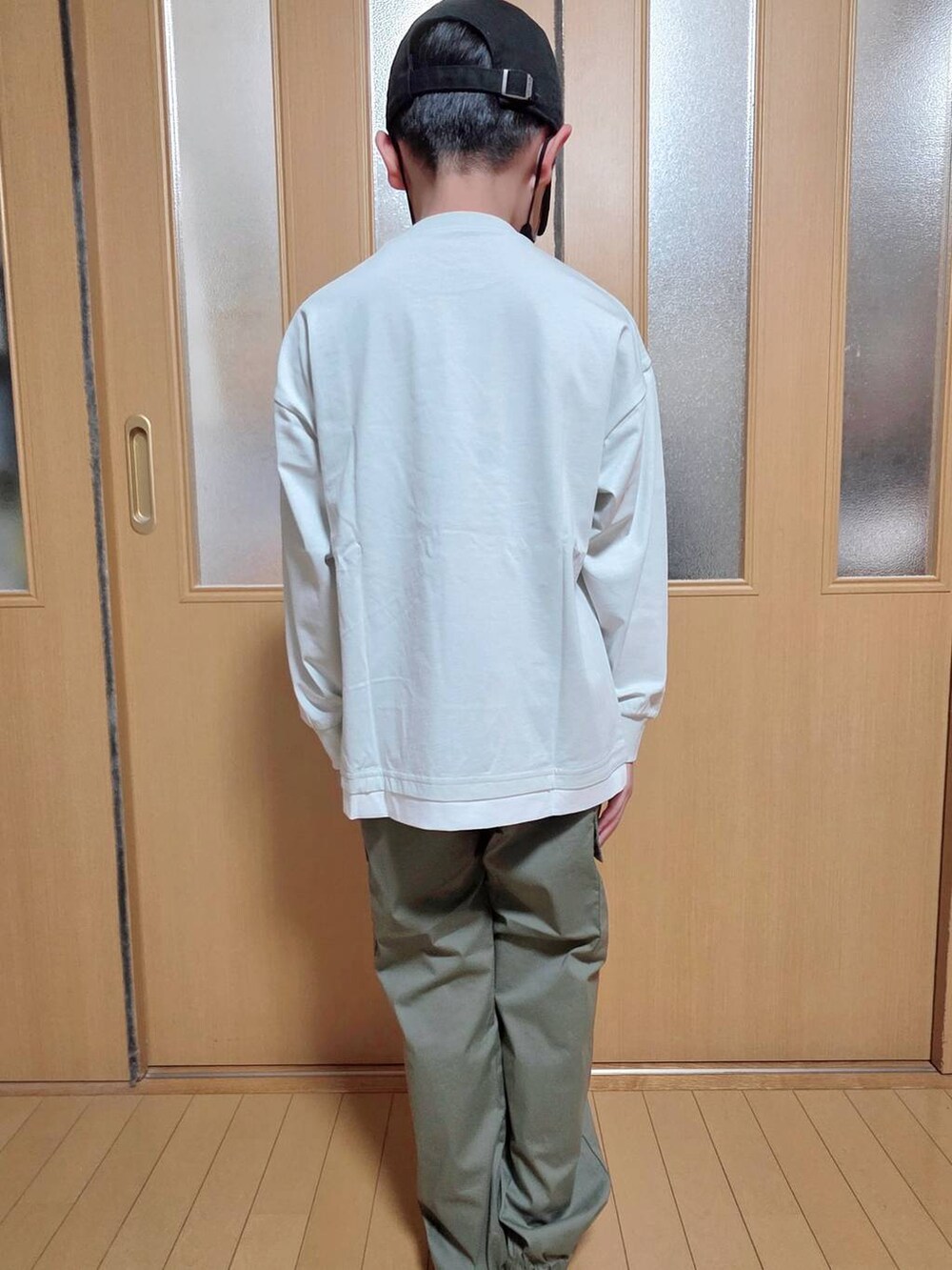 グリーン系のカーゴパンツ、グレー系のTシャツ/カットソー、ブラック系のキャップを着用したキッズの秋コーディネートの3枚目の写真