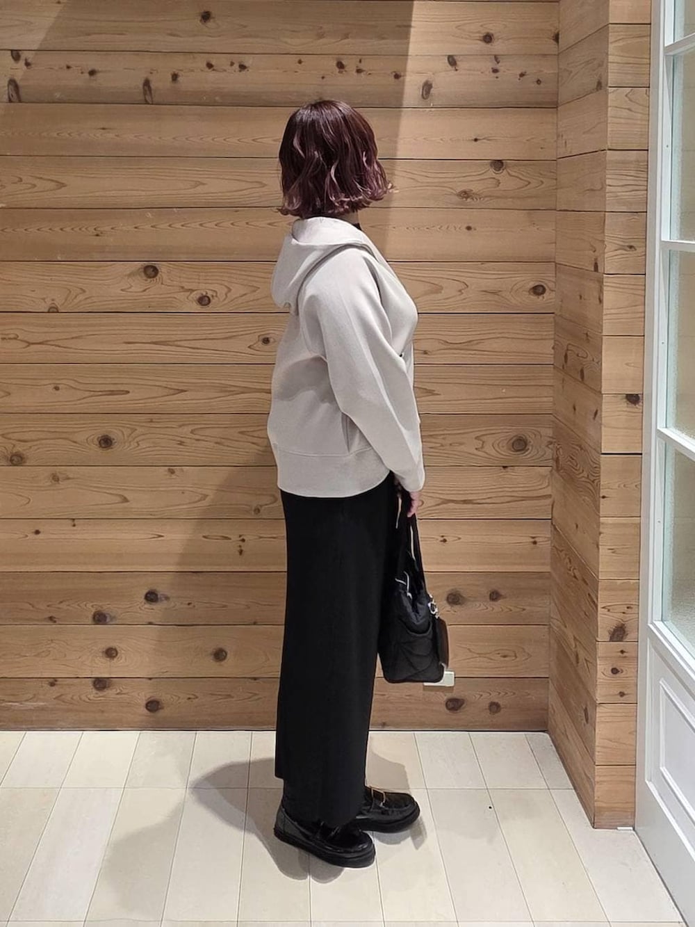 ブラック系のローファー、ブラック系のトートバッグ、ブラック系のTシャツ/カットソーを着用したレディースの冬コーディネートの2枚目の写真