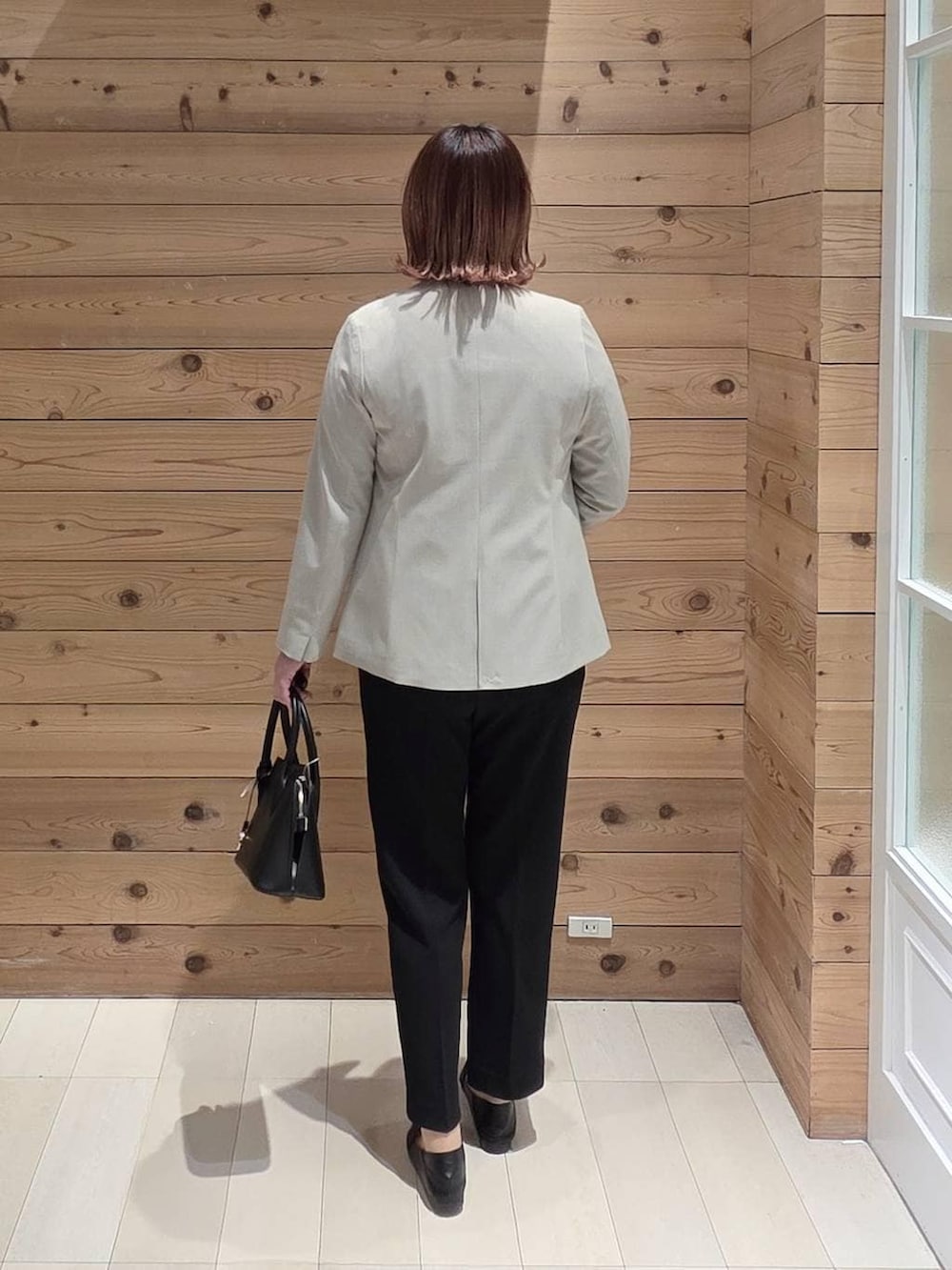 ブラック系のローファー、ブラック系のショルダーバッグ、ブラック系のセットアップを着用したレディースの冬コーディネートの3枚目の写真