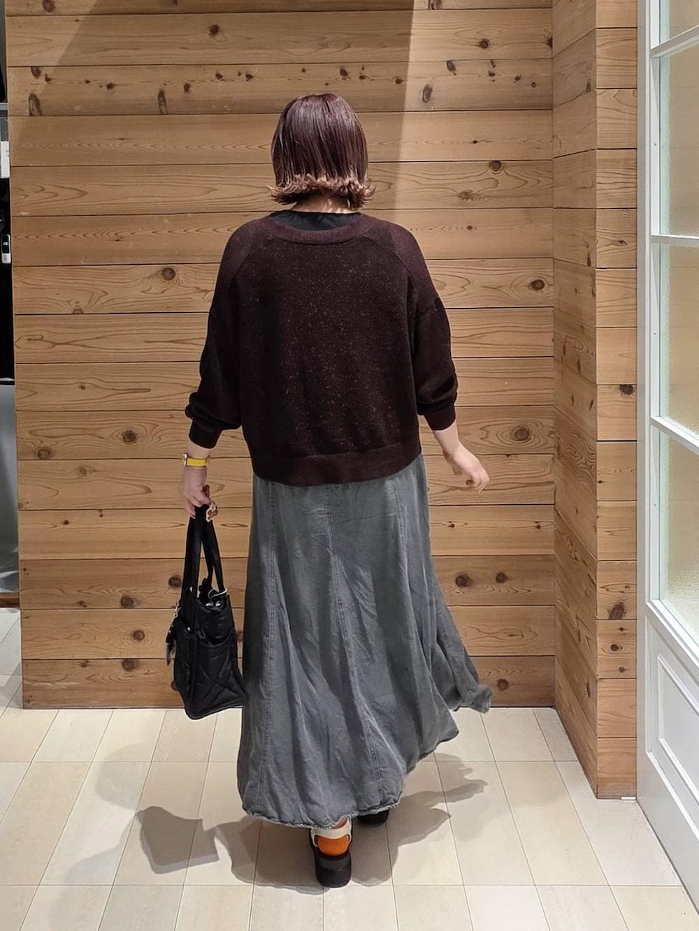 ブラック系のトートバッグ、ブラック系のタンクトップ、ブラック系のデニムスカートを着用したレディースの春コーディネートの3枚目の写真