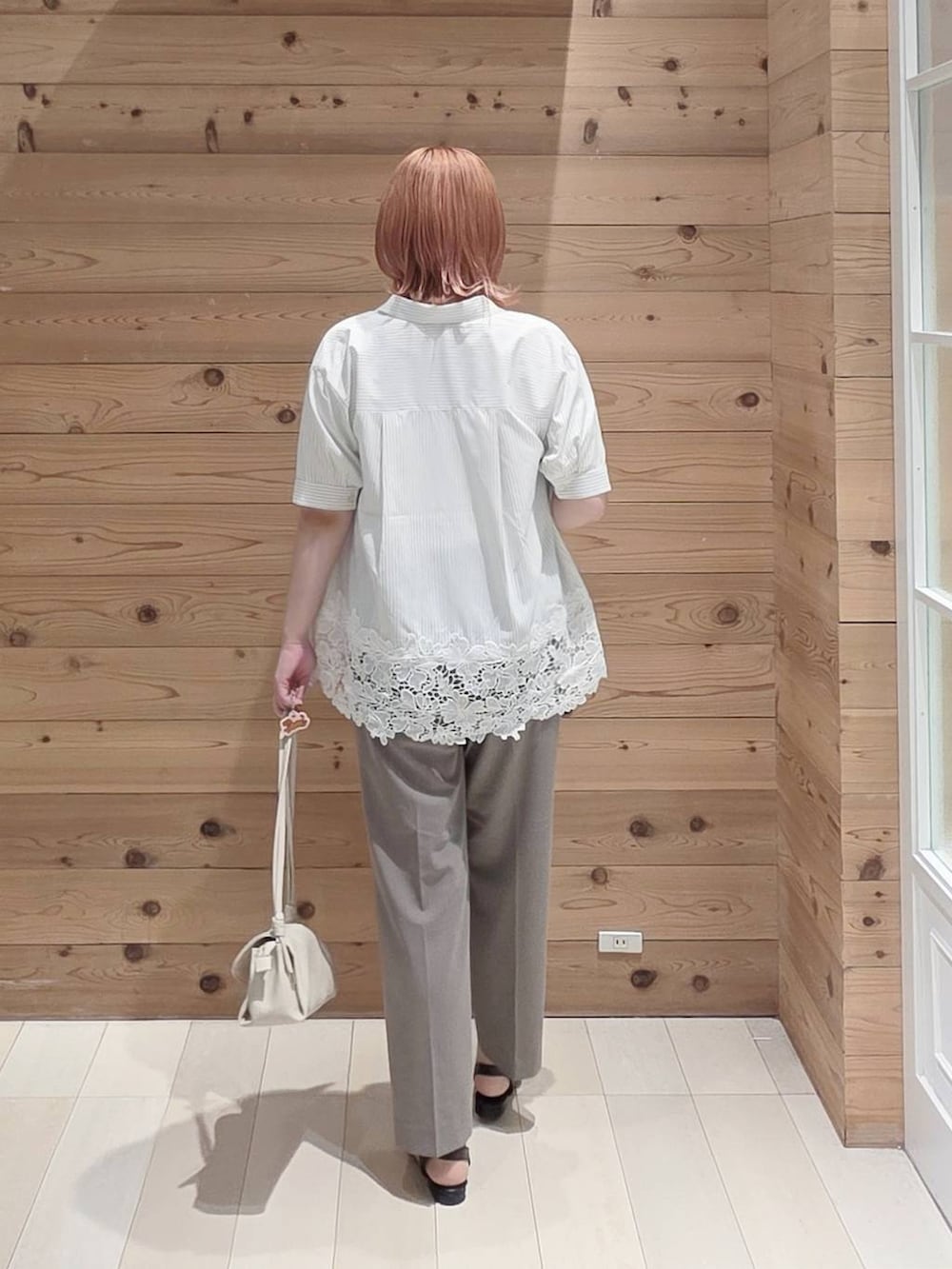 ベージュ系のショルダーバッグ、ブラウン系のその他パンツ、ホワイト系のTシャツ/カットソーを着用したレディースの夏コーディネートの3枚目の写真