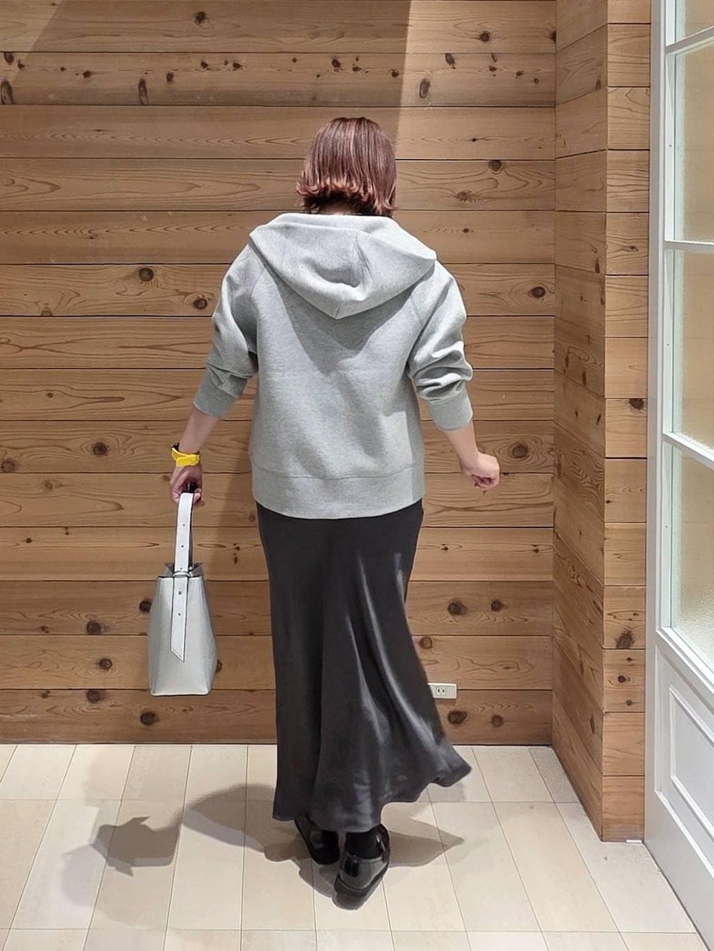 ブラック系のローファー、シルバー系のショルダーバッグ、グレー系のパーカーを着用したレディースの春コーディネートの3枚目の写真