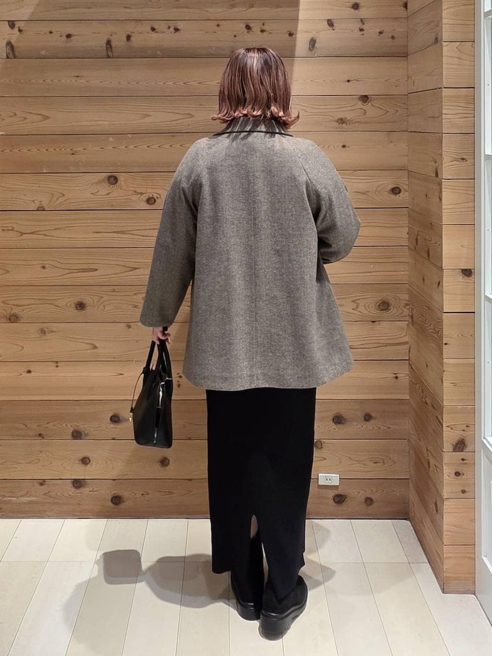 ブラック系のショルダーバッグ、ブラウン系のチェスターコート、ブルー系のシャツ/ブラウスを着用したレディースの冬コーディネートの3枚目の写真