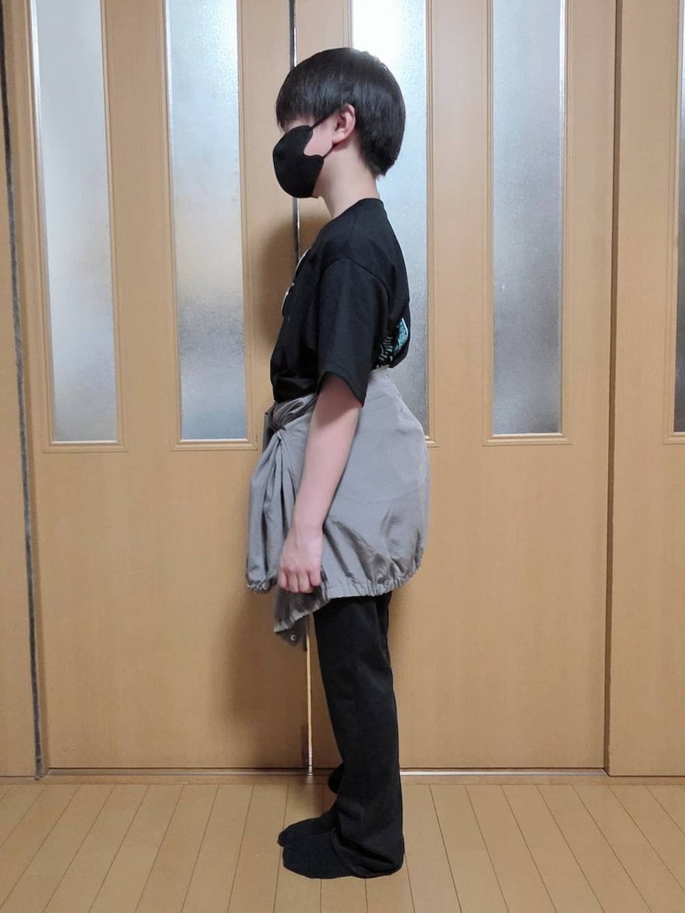 ベージュ系のマウンテンパーカー、ブラック系のデニムパンツ、ブラック系のTシャツ/カットソーを着用したキッズの春コーディネートの2枚目の写真