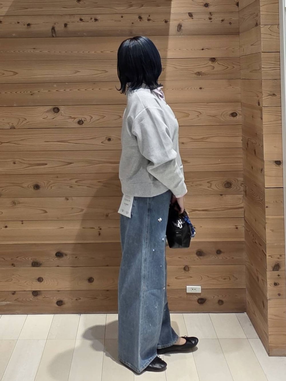 ブルー系のデニムパンツ、グレー系のカーディガン/ボレロ、ブラック系のバレエシューズを着用したレディースの秋コーディネートの2枚目の写真