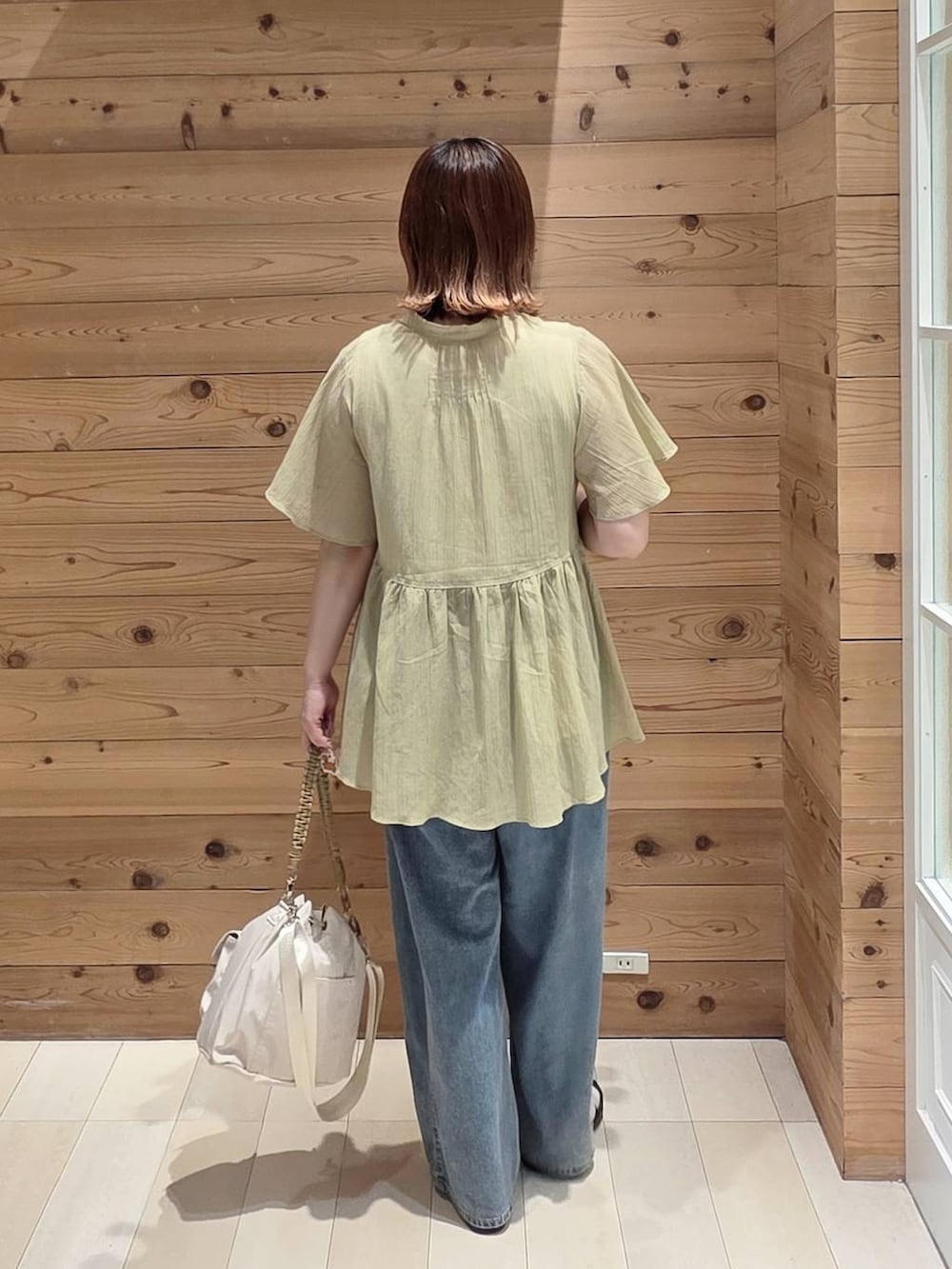 ブルー系のデニムパンツ、ホワイト系のタンクトップ、ベージュ系のサンダルを着用したレディースの夏コーディネートの3枚目の写真