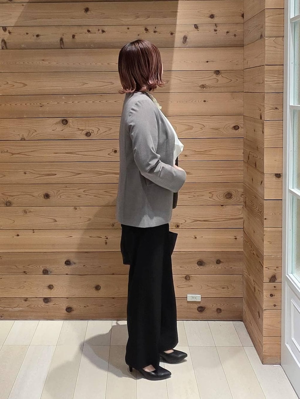 ブラック系のパンプス、ブラック系のスラックス、ホワイト系のシャツ/ブラウスを着用したレディースの冬コーディネートの2枚目の写真