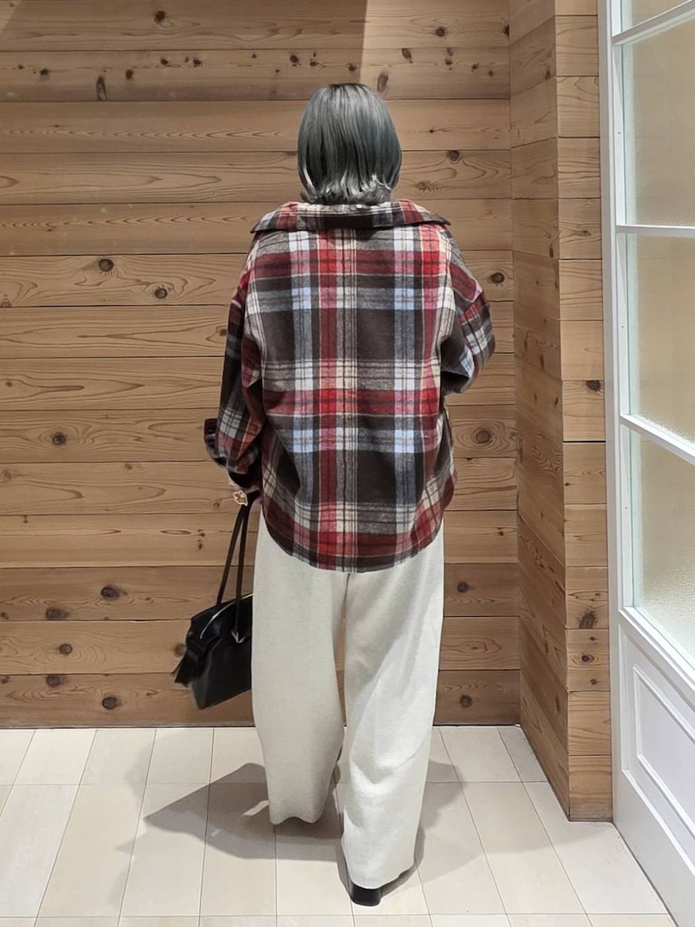 ブラック系のブーツ、ブラック系のボストンバッグ、ホワイト系のTシャツ/カットソーを着用したレディースの秋コーディネートの3枚目の写真