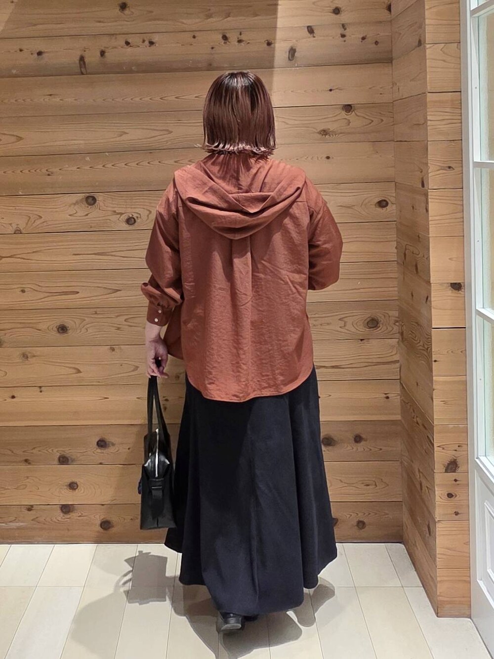 ブラック系のローファー、ブラック系のボストンバッグ、ブラウン系のシャツ/ブラウスを着用したレディースの秋コーディネートの3枚目の写真