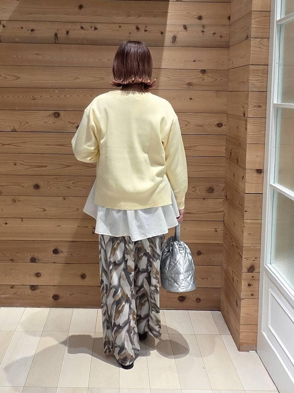 ブラック系のローファー、シルバー系のハンドバッグ、ホワイト系のTシャツ/カットソーを着用したレディースの冬コーディネートの3枚目の写真