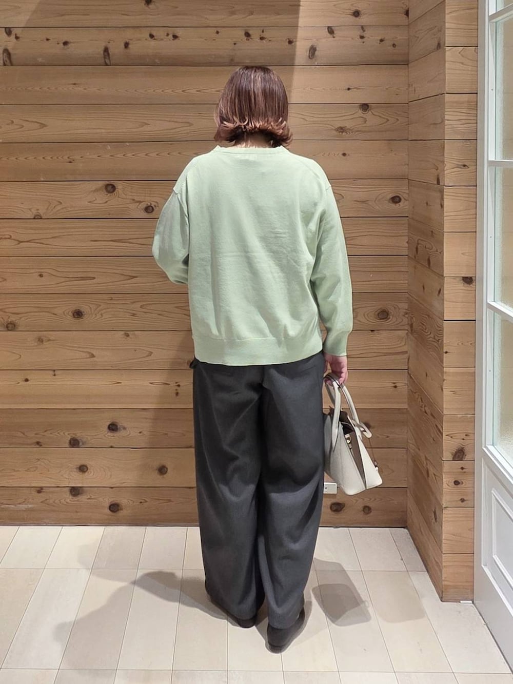 ブラック系のパンプス、ホワイト系のショルダーバッグ、ブラック系のマウンテンパーカーを着用したレディースの春コーディネートの3枚目の写真