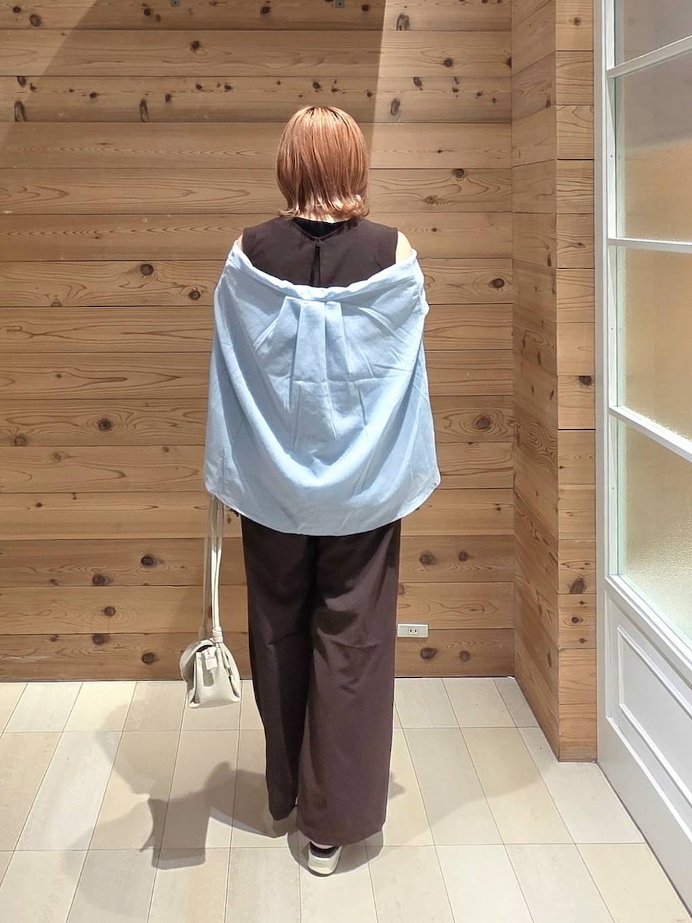 ベージュ系のショルダーバッグ、ブルー系のシャツ/ブラウス、ブラック系のサンダルを着用したレディースの夏コーディネートの3枚目の写真