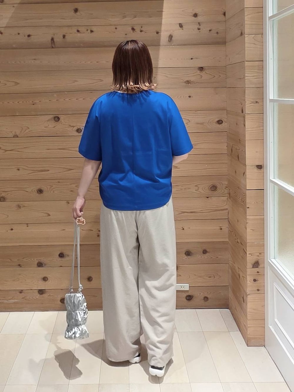 ベージュ系のその他パンツ、ブルー系のTシャツ/カットソー、ブラック系のサンダルを着用したレディースの夏コーディネートの3枚目の写真