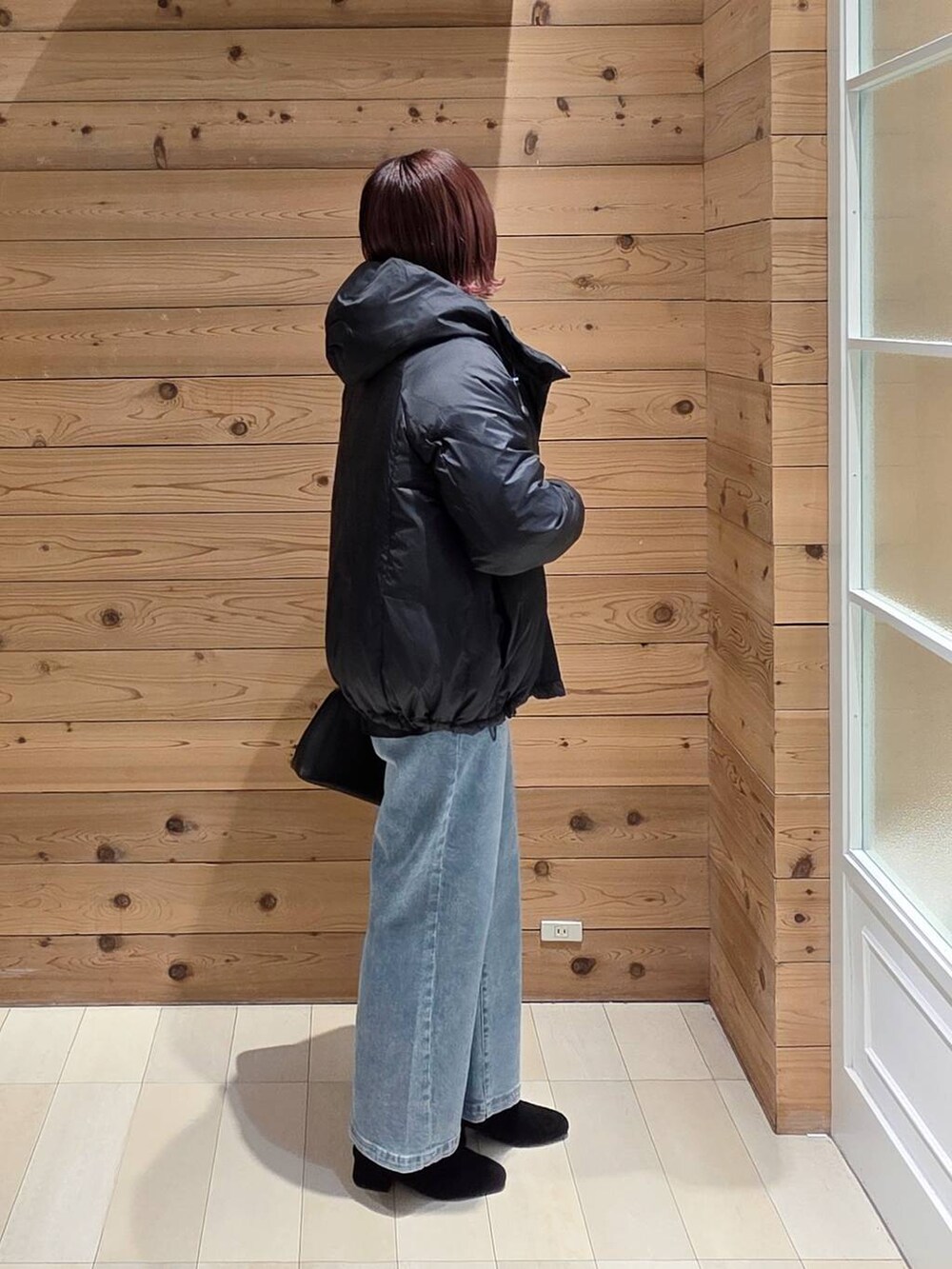 ブラック系のショルダーバッグ、ブラック系のダウンジャケット/コート、ブラック系のTシャツ/カットソーを着用したレディースの冬コーディネートの2枚目の写真