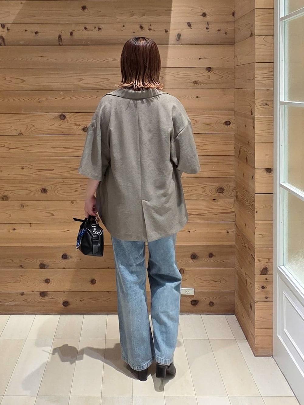ブルー系のデニムパンツ、ブラウン系のテーラードジャケット、ホワイト系のTシャツ/カットソーを着用したレディースの夏コーディネートの3枚目の写真