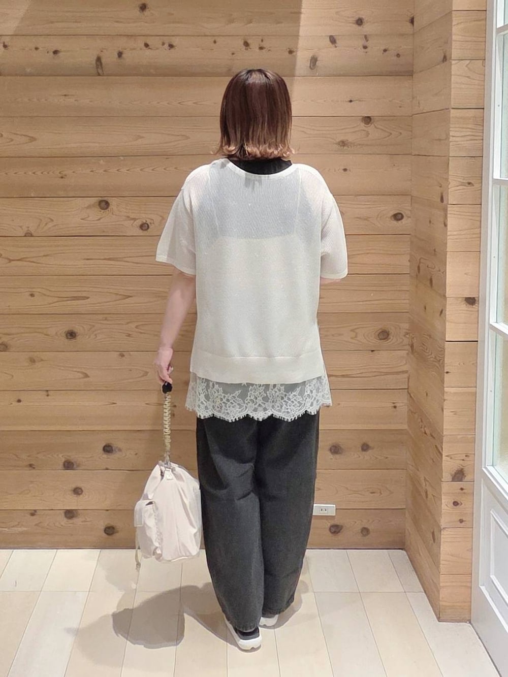ブラック系のデニムパンツ、ブラック系のタンクトップ、ホワイト系のキャミソールを着用したレディースの夏コーディネートの3枚目の写真