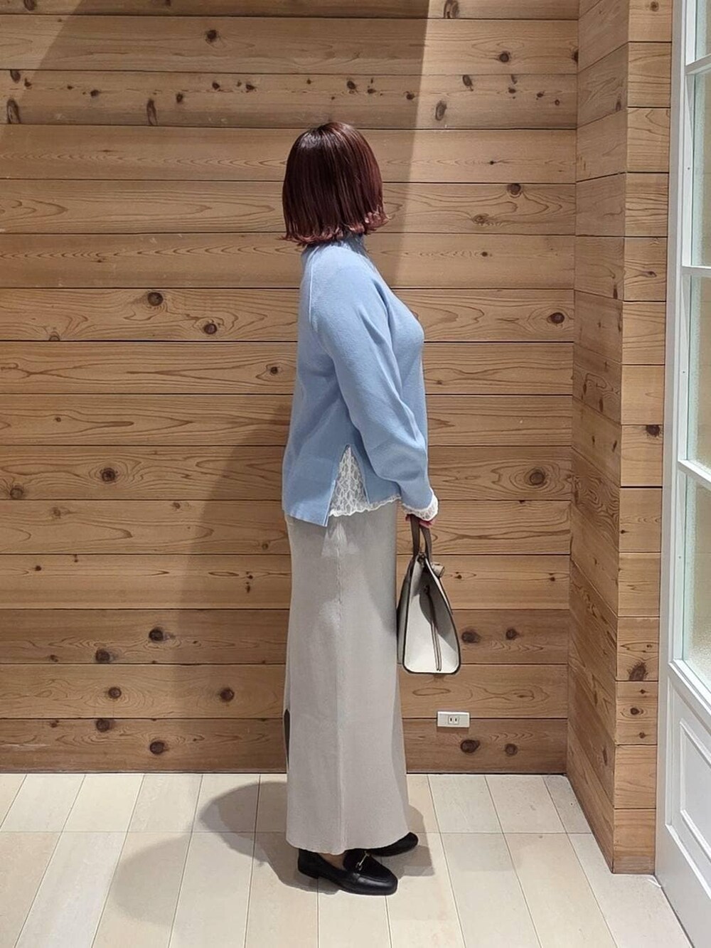 ブラック系のローファー、ホワイト系のショルダーバッグ、ホワイト系のTシャツ/カットソーを着用したレディースの冬コーディネートの2枚目の写真